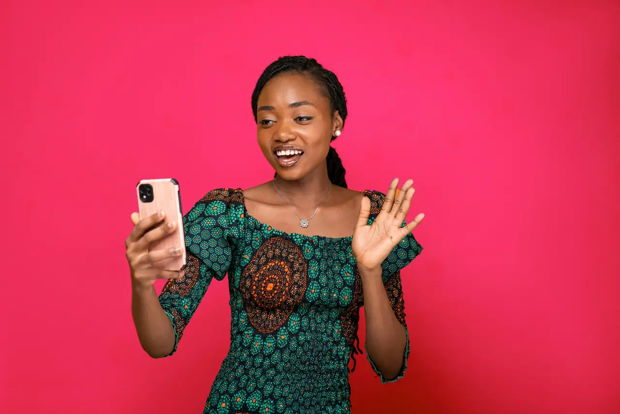 Mulher acenando em uma chamada de vídeo no celular