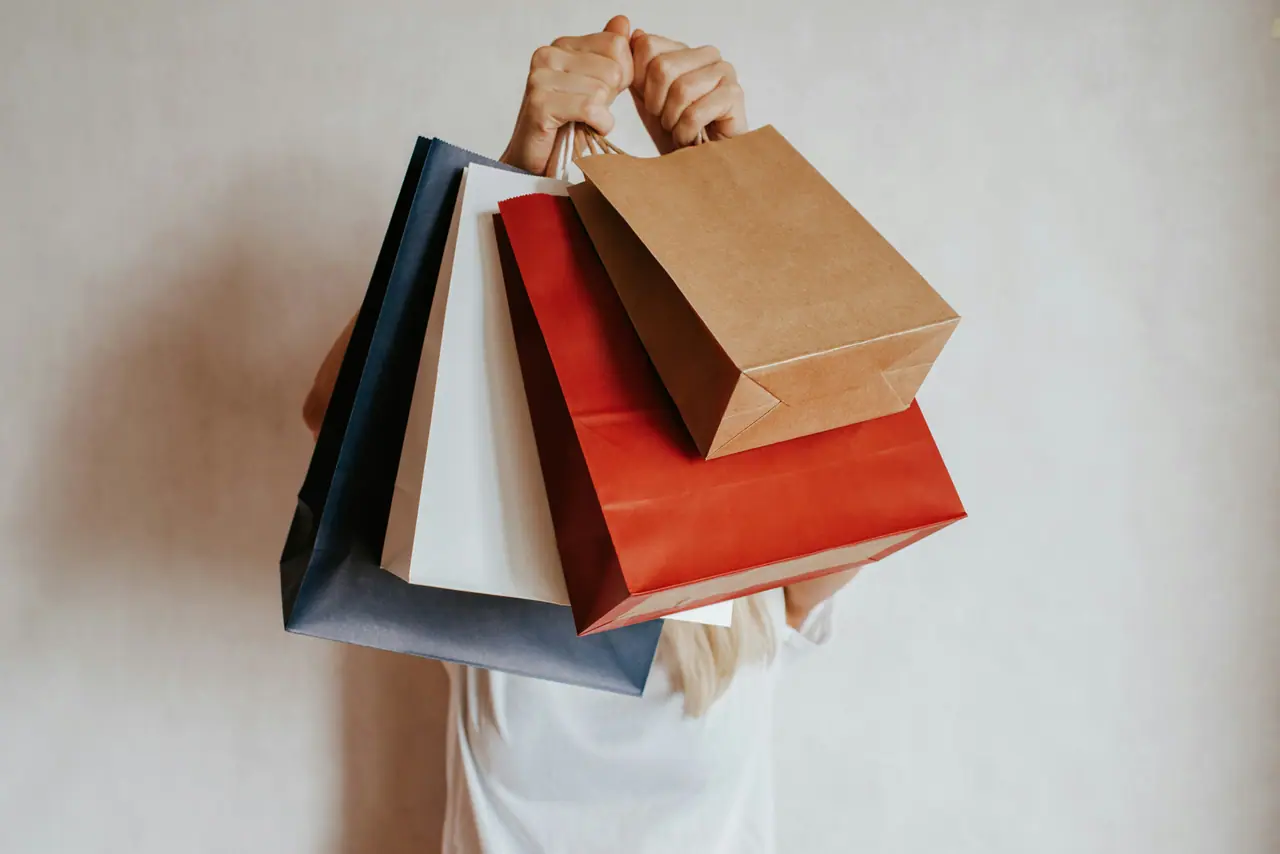 Pessoa segurando várias sacolas de compras
